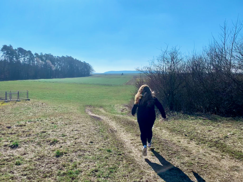 Frau läuft in die Natur, strahlend blauer Himmel- Basti-Tours Reiseblog