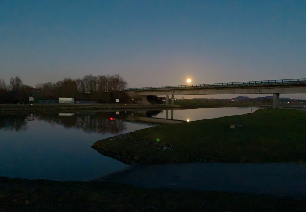 Abenddämmerung an einem Fluss mit einer Brücke