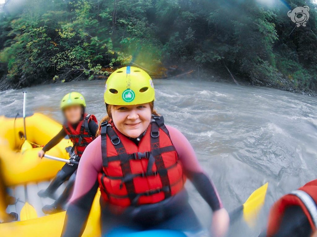 Frau mit Schwimmweste und Helm in einem Schlauchboot, Rafting in Österreich, Salzach Wildwasser