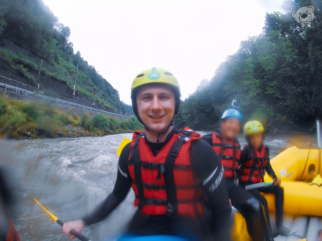 Mann mit Schwimmweste und Helm auf einem gelben Schlauchboot, Wildwasser Rafting in Österreich